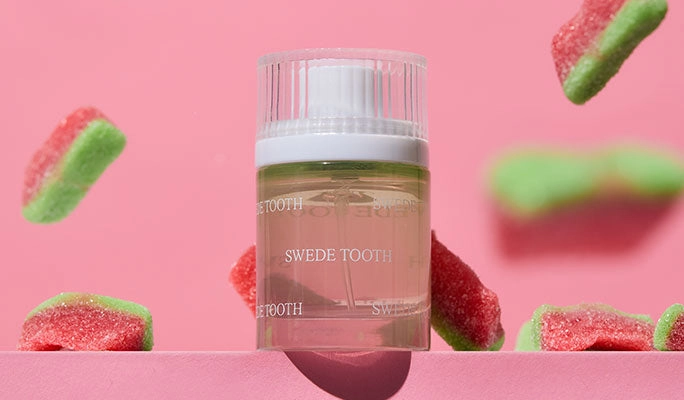A fragrance bottle among floating watermelon candy