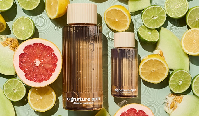 Laundry bottles among sliced grapefruit and limes
