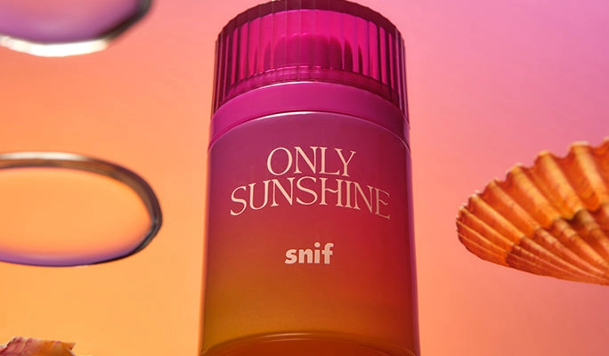 A pink Only Sunshine bottle beside a seashell