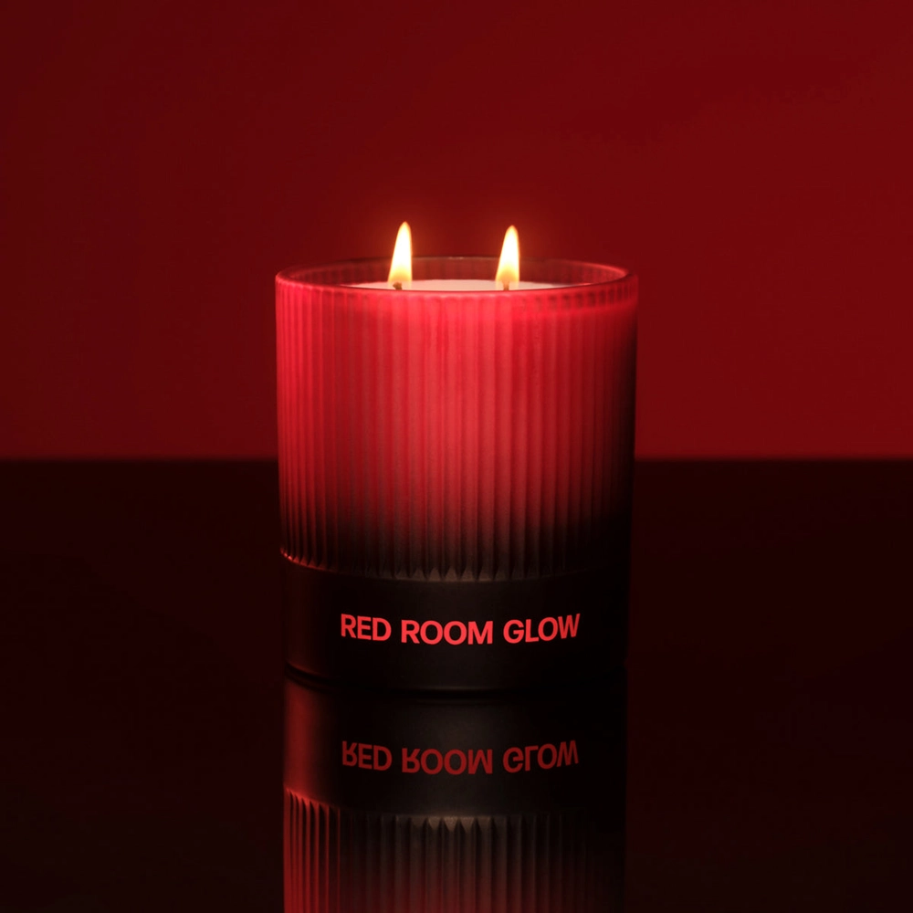 Red Room Glow candle lit against a deep red backdrop