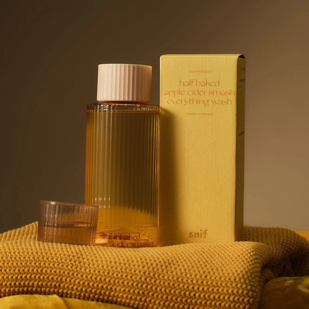 A laundry detergent bottle on a yellow knit blanket